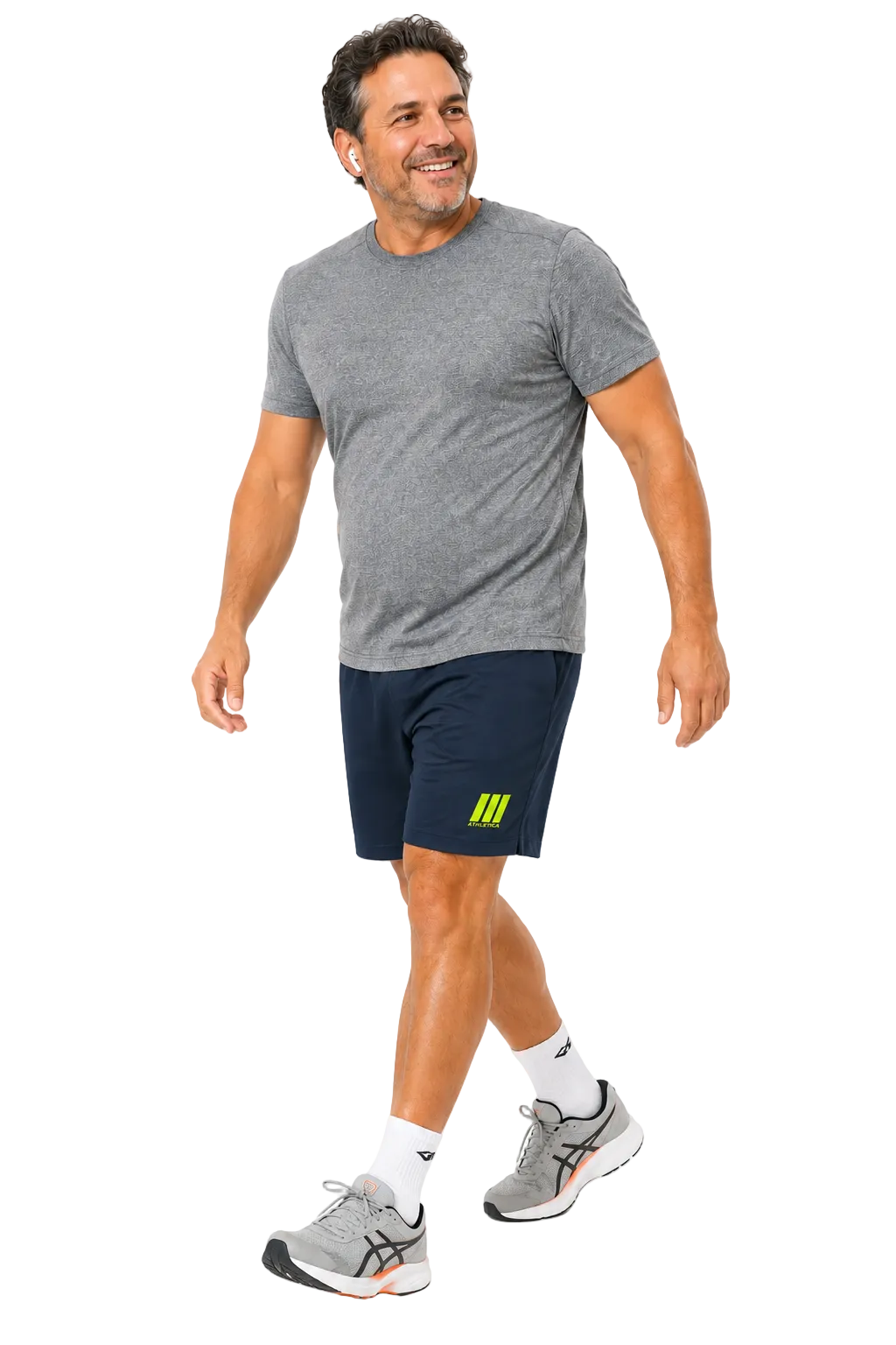 A man wearing a heather gray short-sleeve athletic t-shirt, navy blue athletic shorts with a yellow logo, white socks, and gray running shoes, walking against a solid white background.